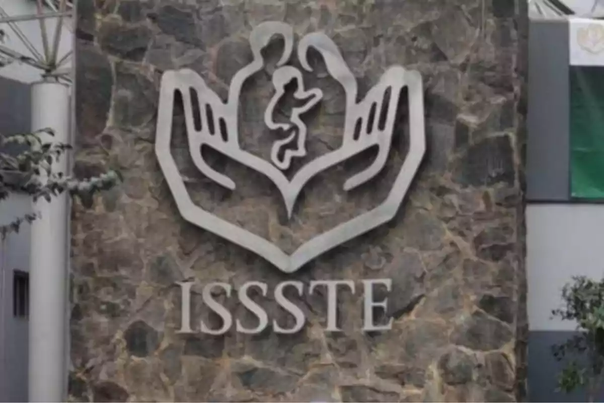 Logotipo del ISSSTE en una pared de piedra.