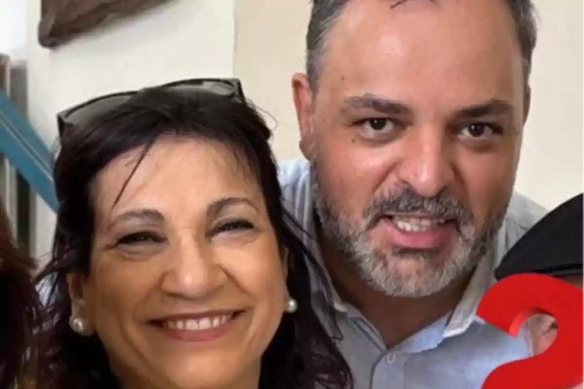 Una mujer y un hombre sonríen juntos mirando a la cámara en un ambiente interior Una mujer y un hombre sonríen juntos mirando a la cámara en un ambiente interior