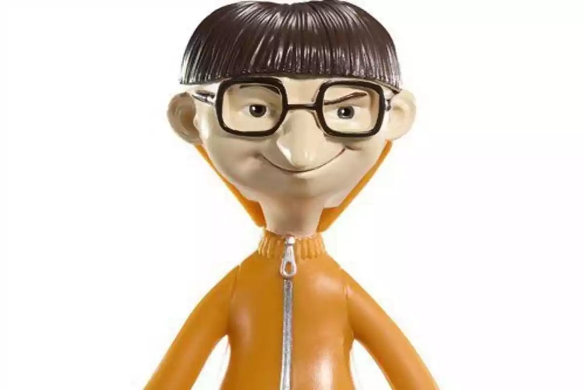 Muñeco de personaje animado con gafas grandes, cabello lacio y corto, y un traje naranja con cierre plateado.