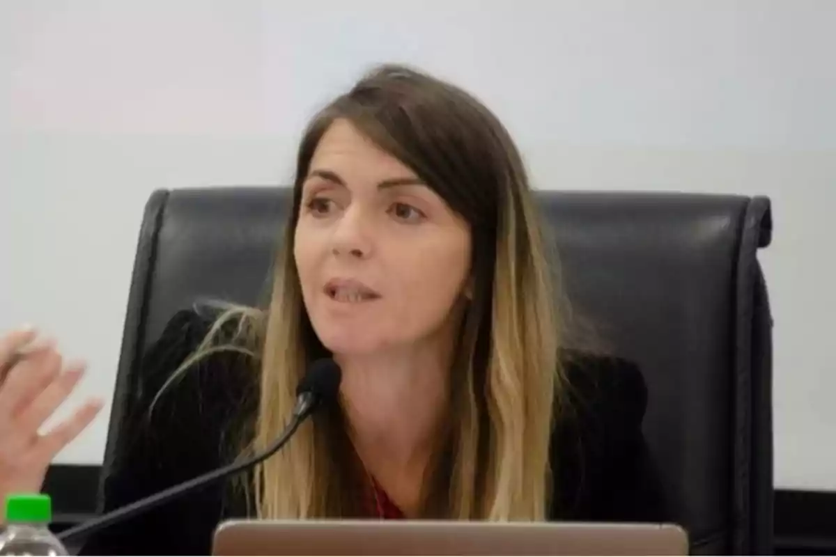 Woman speaking into a microphone during a conference.