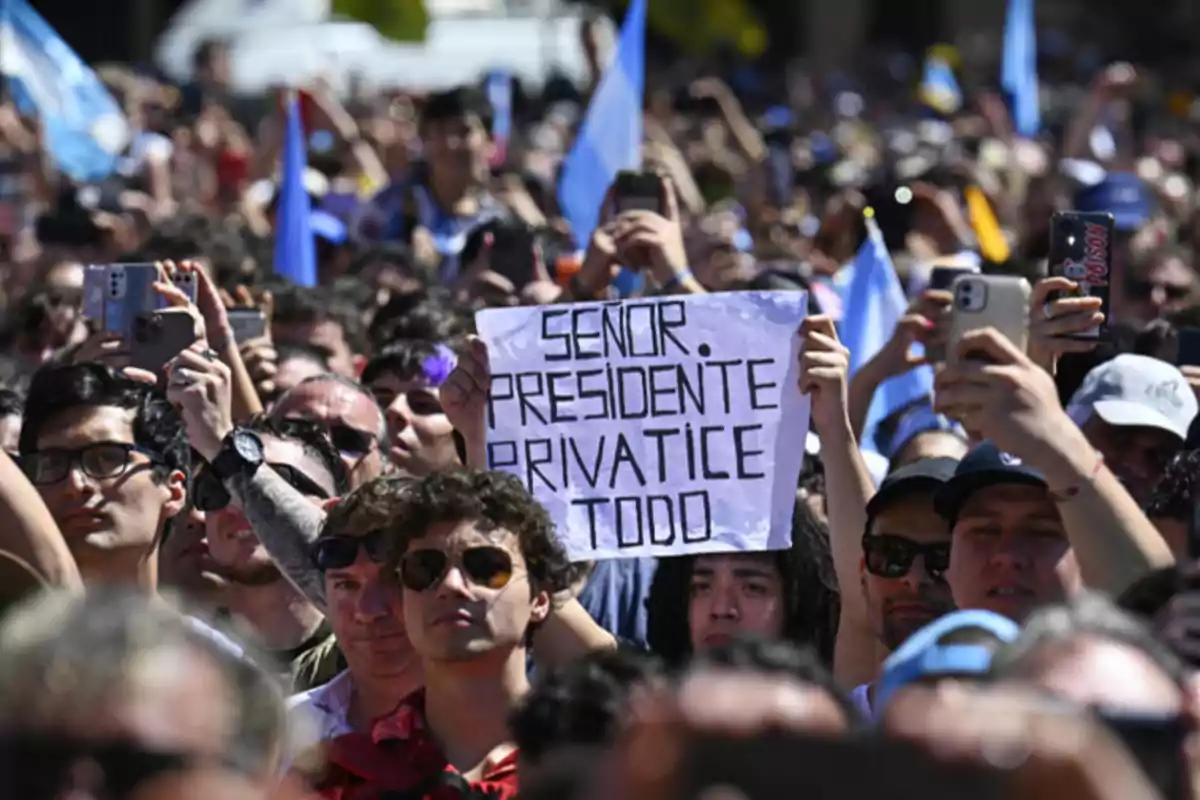 Una multitud de personas en una manifestación, con una persona sosteniendo un cartel que dice "SEÑOR PRESIDENTE PRIVATICE TODO".