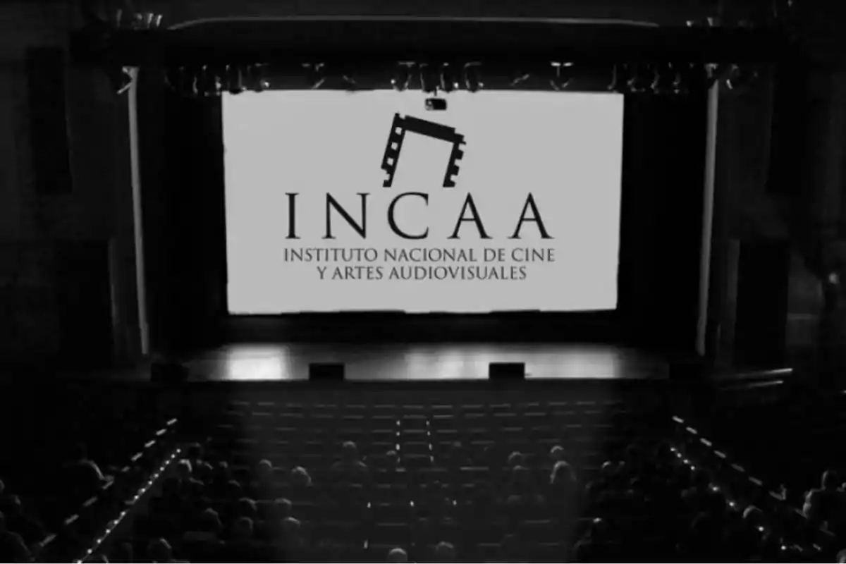 Una sala de cine con una pantalla que muestra el logo del INCAA, Instituto Nacional de Cine y Artes Audiovisuales.