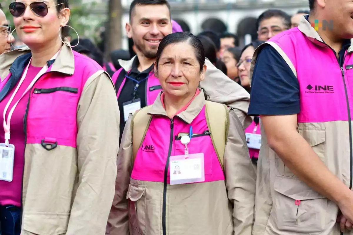 Un grupo de personas con chalecos del INE, algunas llevan gafetes de identificación.