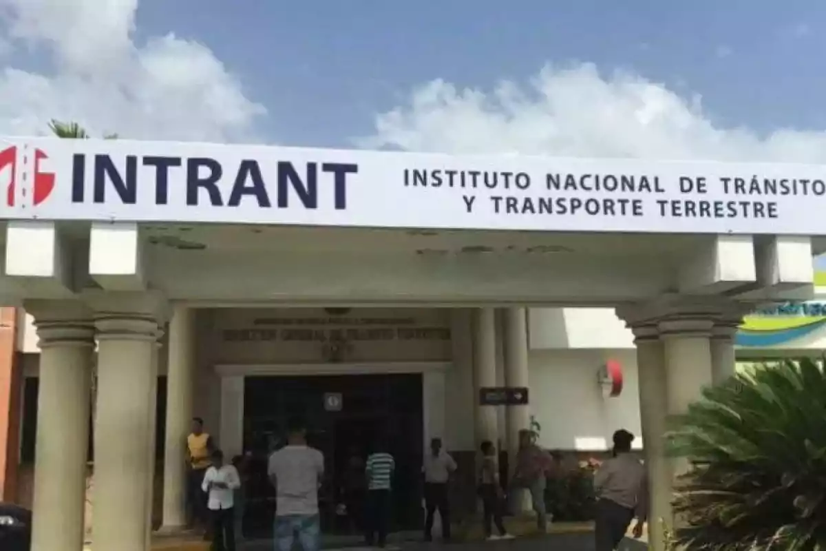 Fachada del Instituto Nacional de Tránsito y Transporte Terrestre con varias personas en la entrada