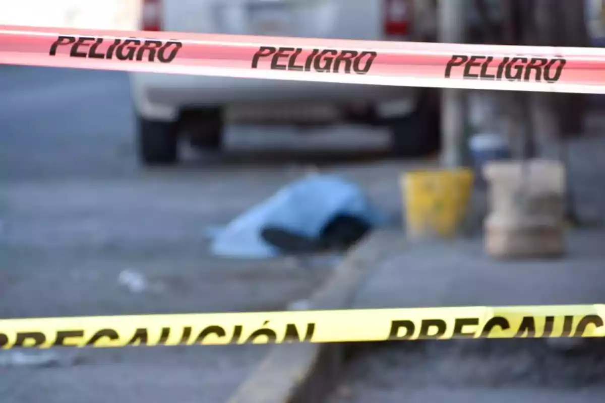 Cinta de precaución y peligro en una escena urbana con un objeto cubierto en el suelo. Cinta de precaución y peligro en una escena urbana con un objeto cubierto en el suelo.