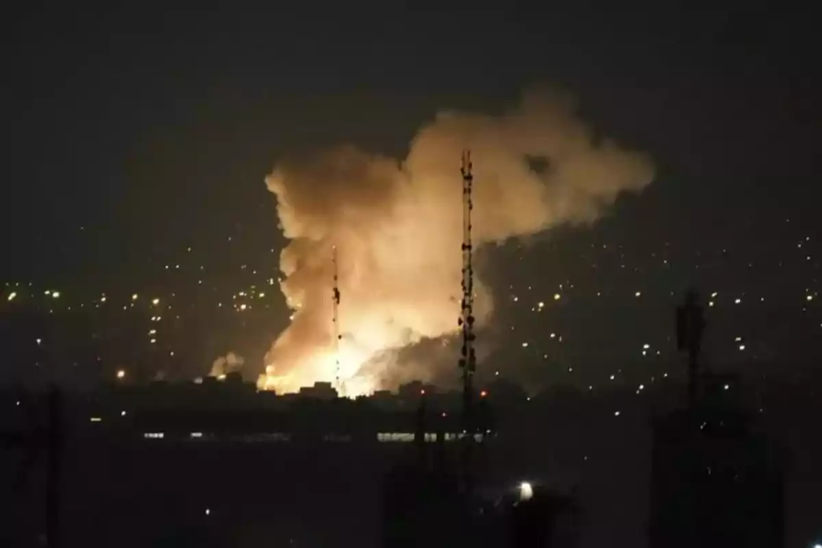 Nighttime explosion in a city with a large illuminated smoke cloud and city lights in the background Nighttime explosion in a city with a large illuminated smoke cloud and city lights in the background
