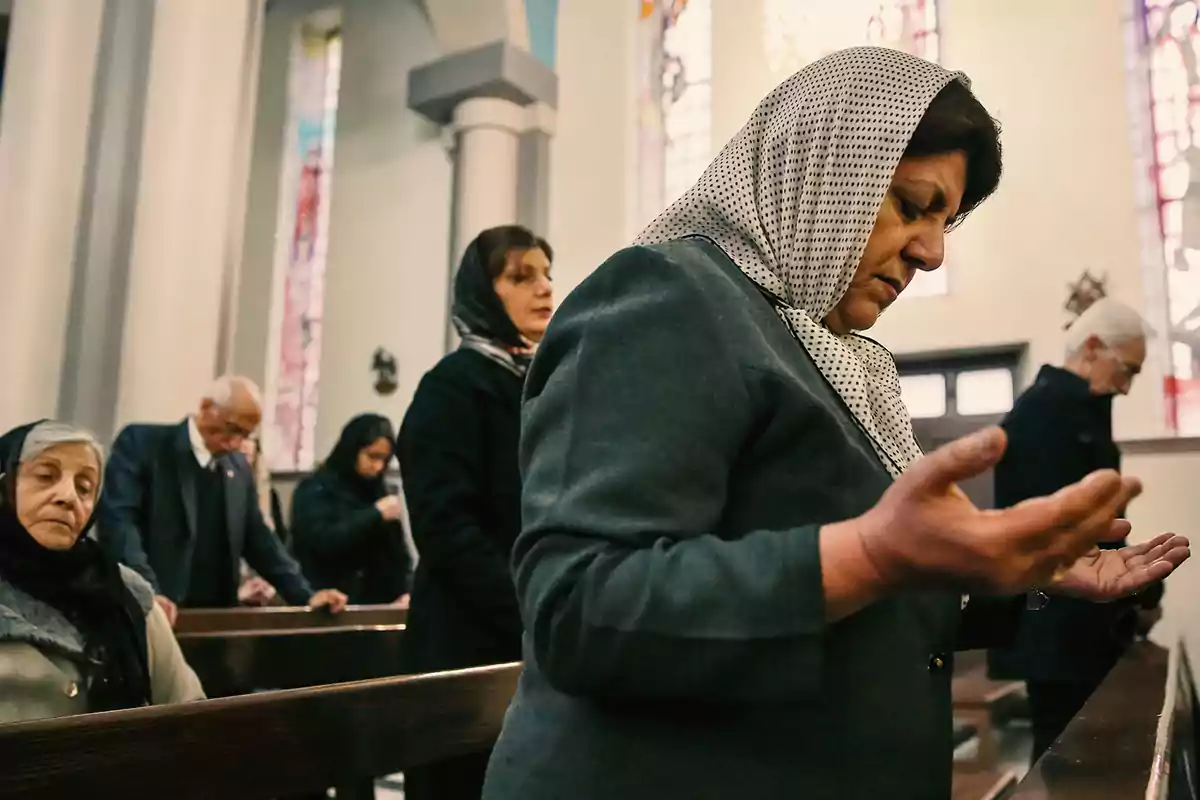 Personas rezando en el interior de una iglesia. Personas rezando en el interior de una iglesia.