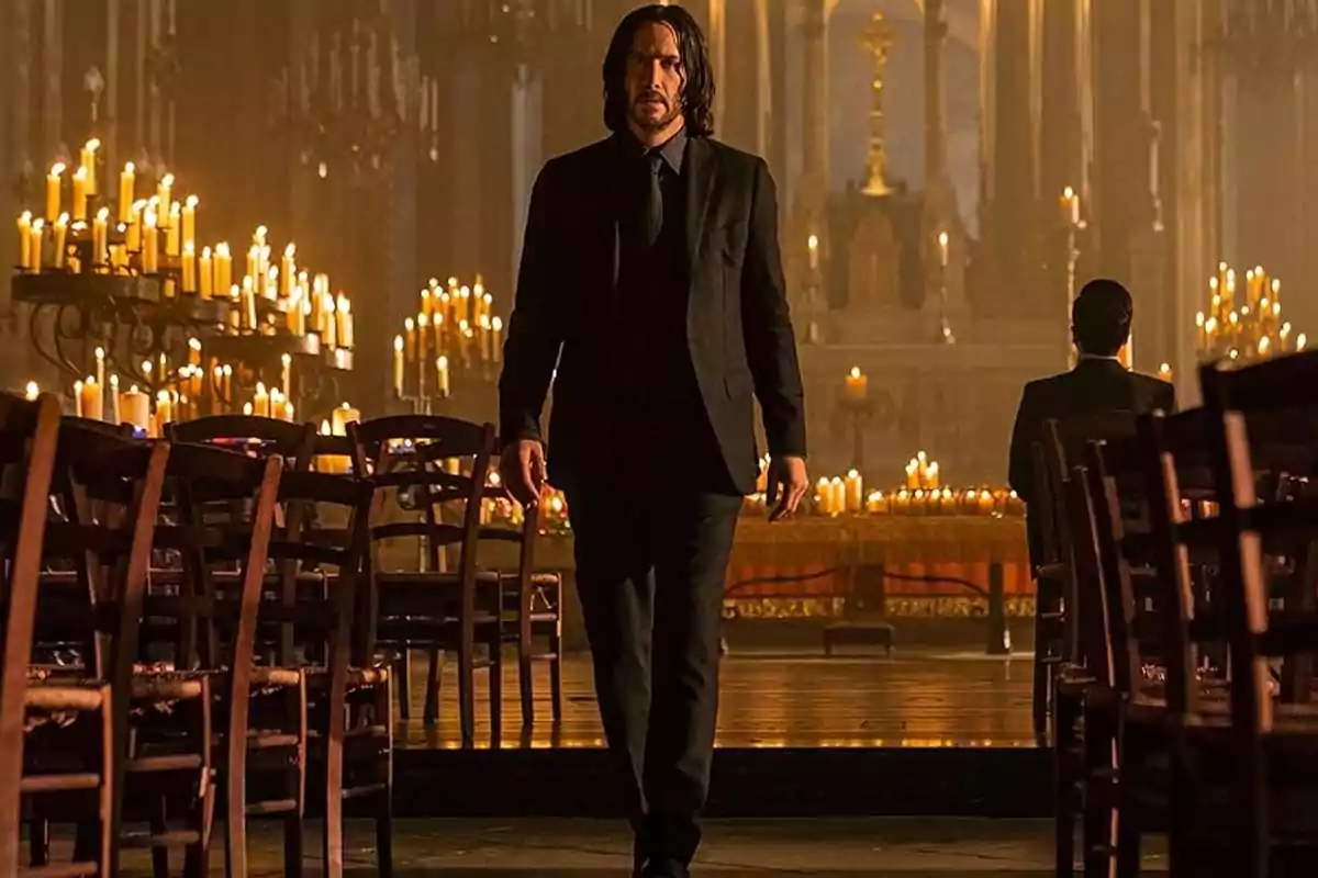 Long-haired man in a black suit walking between rows of chairs in a church lit by many candles Long-haired man in a black suit walking between rows of chairs in a church lit by many candles