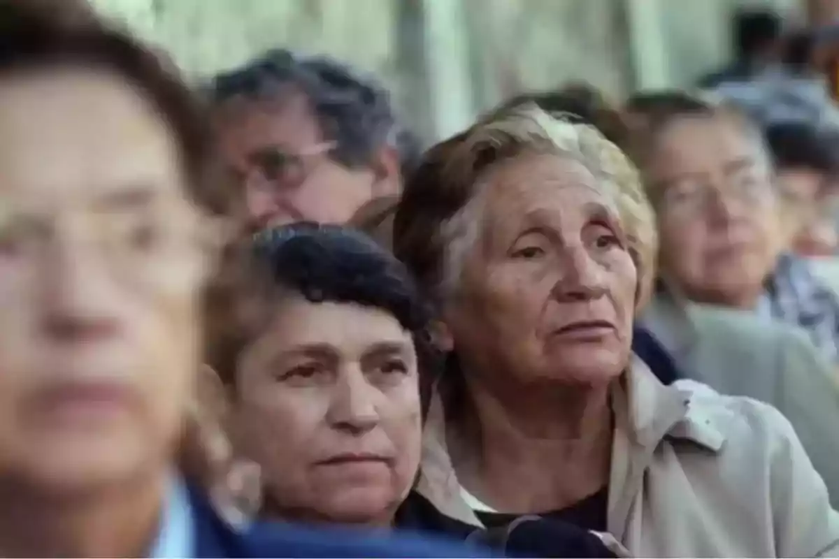 Un grupo de personas mayores observando atentamente en un entorno al aire libre.