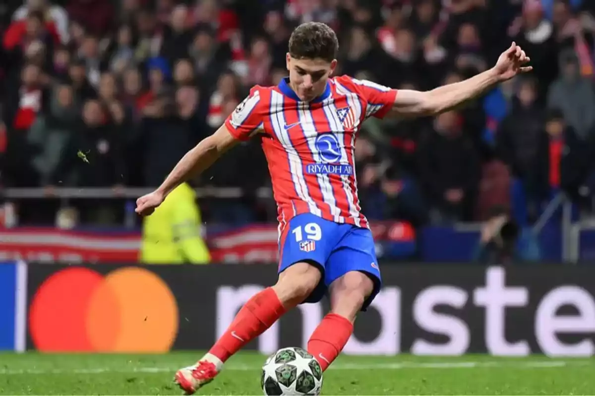 Futbolista del Atlético de Madrid pateando un balón durante un partido con público en el estadio