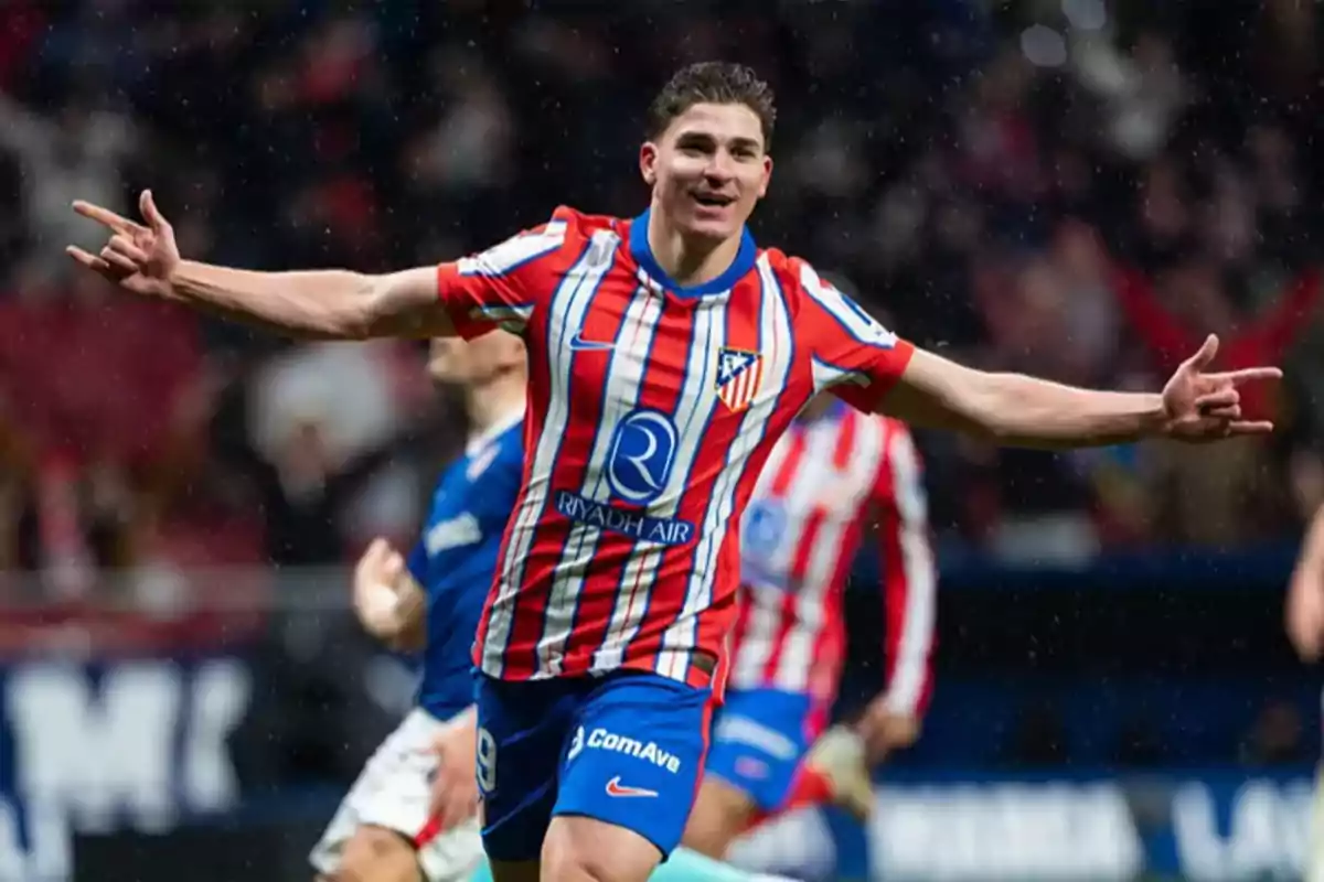 A player in a red and white uniform celebrates a goal on the field.