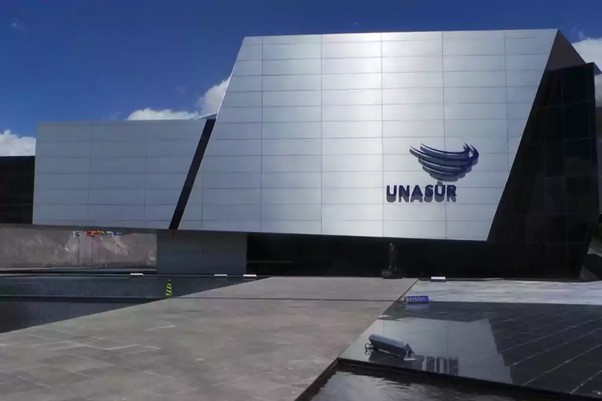 Modern building with a metallic facade and UNASUR logo.