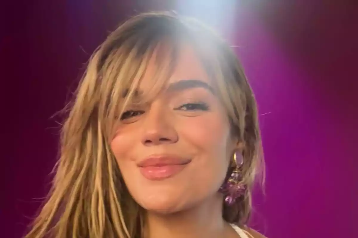 Mujer joven sonriendo con fondo morado y luz brillante sobre su cabeza