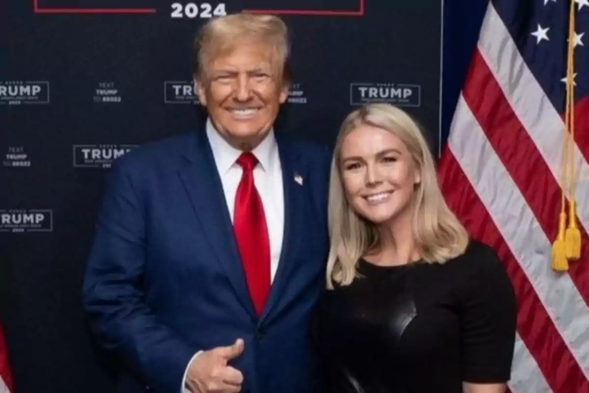 Donald Trump y Karoline Leavitt, secretaria de prensa de la Casa Blanca, posando frente a un fondo con banderas estadounidenses.