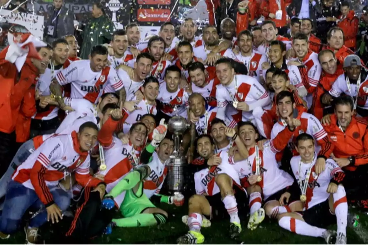 Un equipo de fútbol celebrando con un trofeo en el campo. Un equipo de fútbol celebrando con un trofeo en el campo.