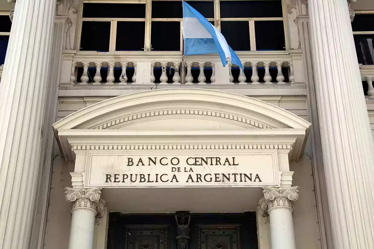 Fachada del Banco Central de la República Argentina con una bandera argentina ondeando.