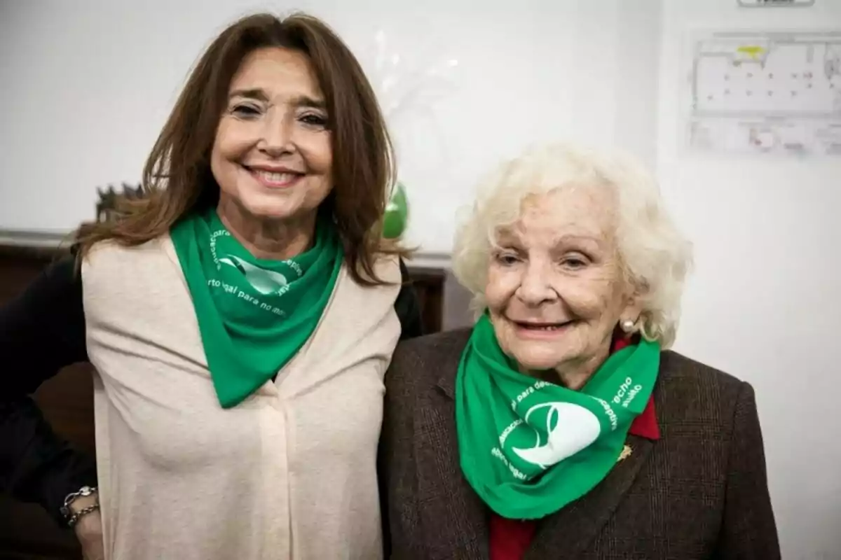 Dos mujeres sonríen usando pañuelos verdes en el cuello en apoyo a la legalización del aborto. Dos mujeres sonríen usando pañuelos verdes en el cuello en apoyo a la legalización del aborto.