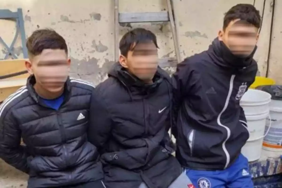 Tres personas sentadas con chaquetas deportivas en un entorno exterior. Tres personas sentadas con chaquetas deportivas en un entorno exterior.