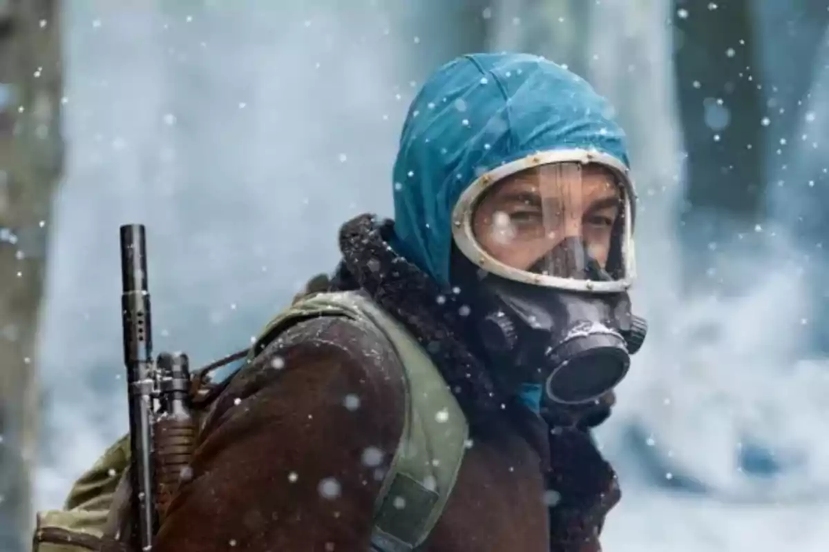 Person with a gas mask and blue hood in a snowy environment. Person with a gas mask and blue hood in a snowy environment.