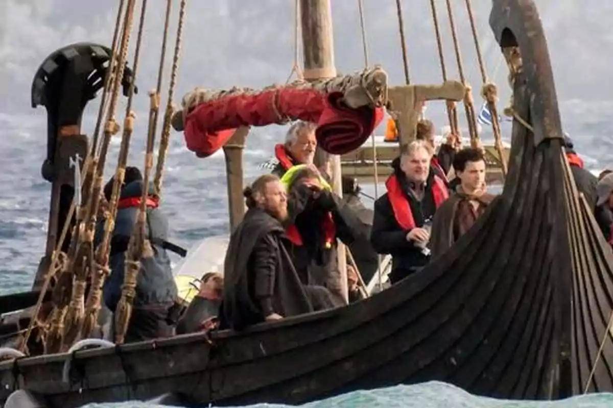 A group of people on a Viking-style boat sailing in the sea. A group of people on a Viking-style boat sailing in the sea.