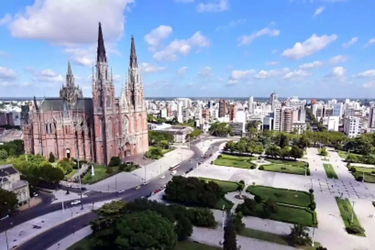 Vista aérea de una catedral gótica rodeada de una plaza y edificios en una ciudad.