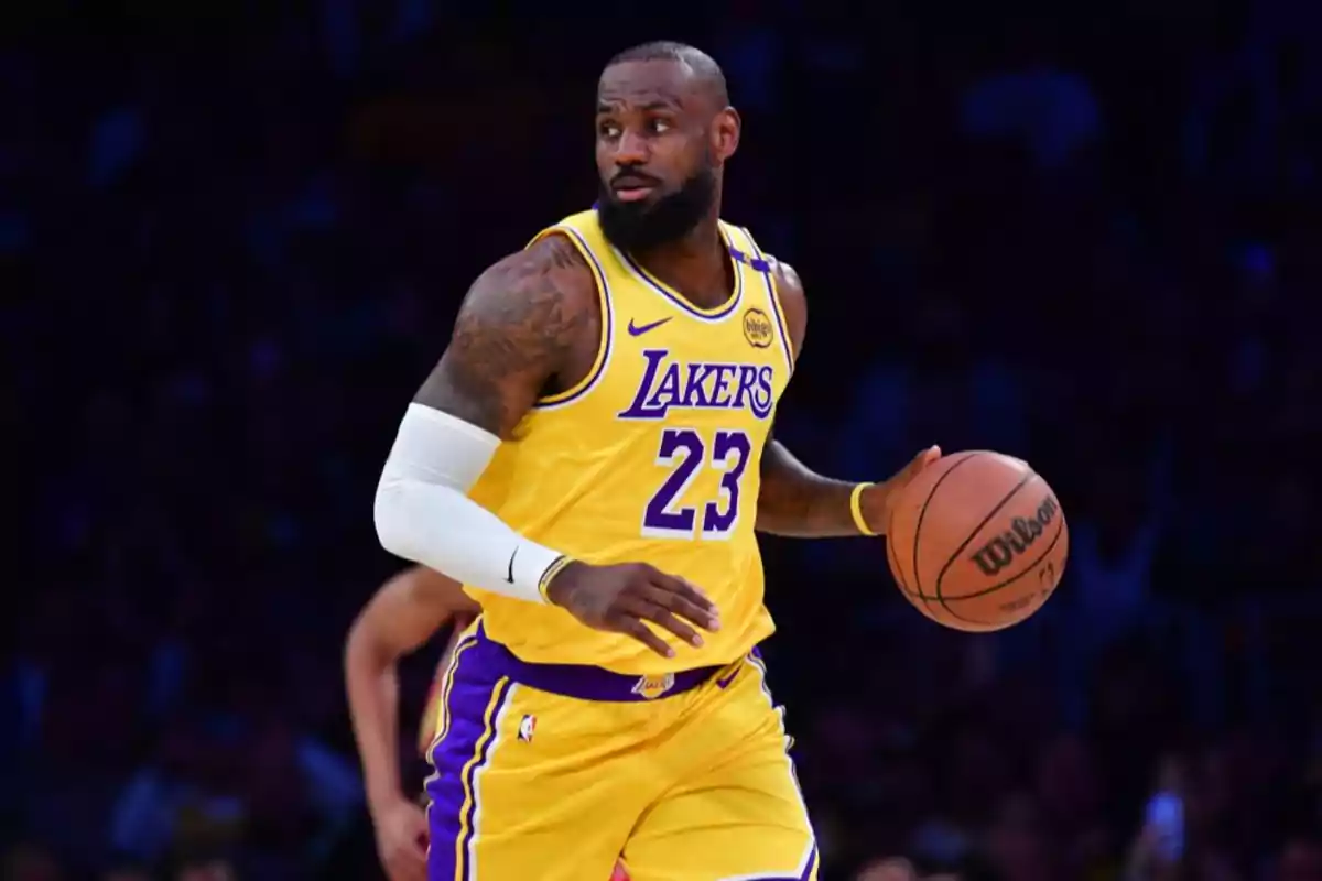 Basketball player in a yellow Lakers uniform holding a ball during a game.