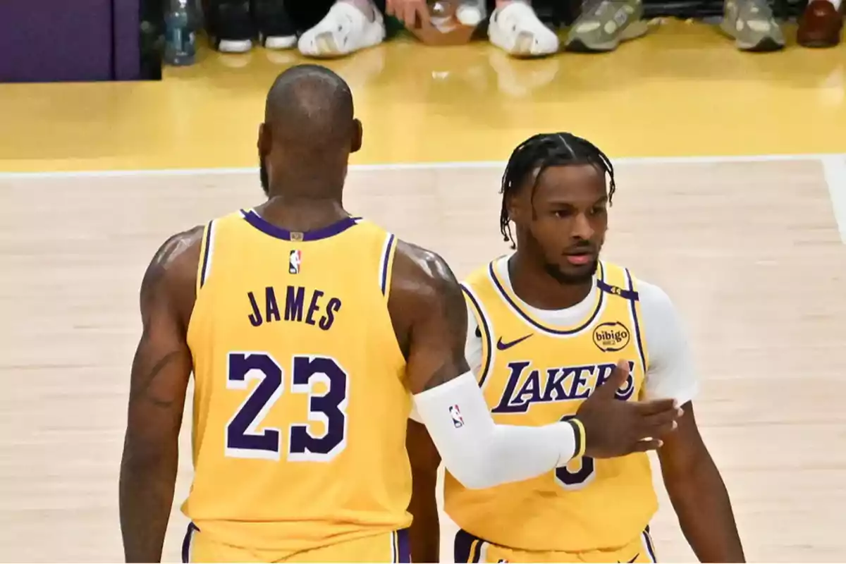 Two basketball players in yellow Lakers uniforms on the court during a game. Two basketball players in yellow Lakers uniforms on the court during a game.
