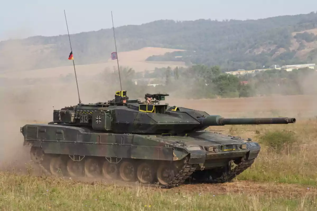Leopard 2 military tank moving across a field terrain with hills in the background and dust rising in its wake Leopard 2 military tank moving across a field terrain with hills in the background and dust rising in its wake