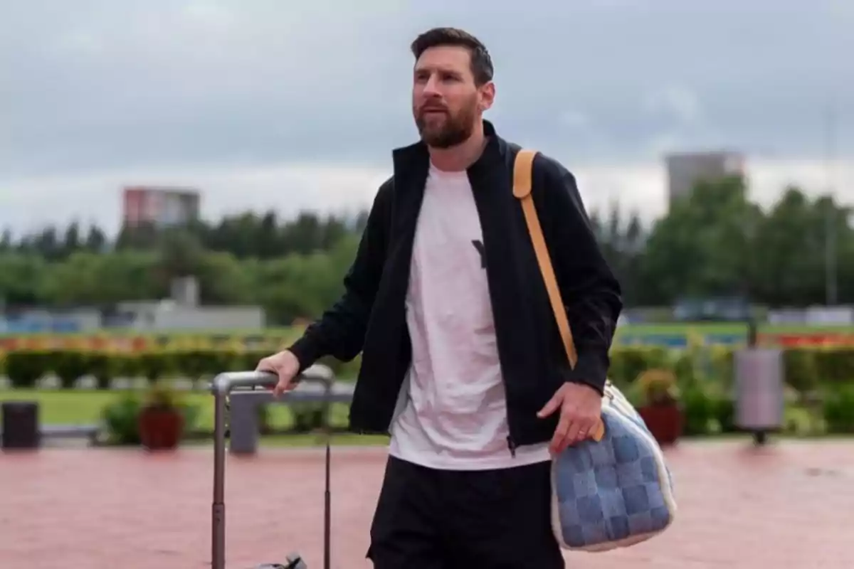 Hombre con barba caminando al aire libre con una maleta y un bolso. Hombre con barba caminando al aire libre con una maleta y un bolso.