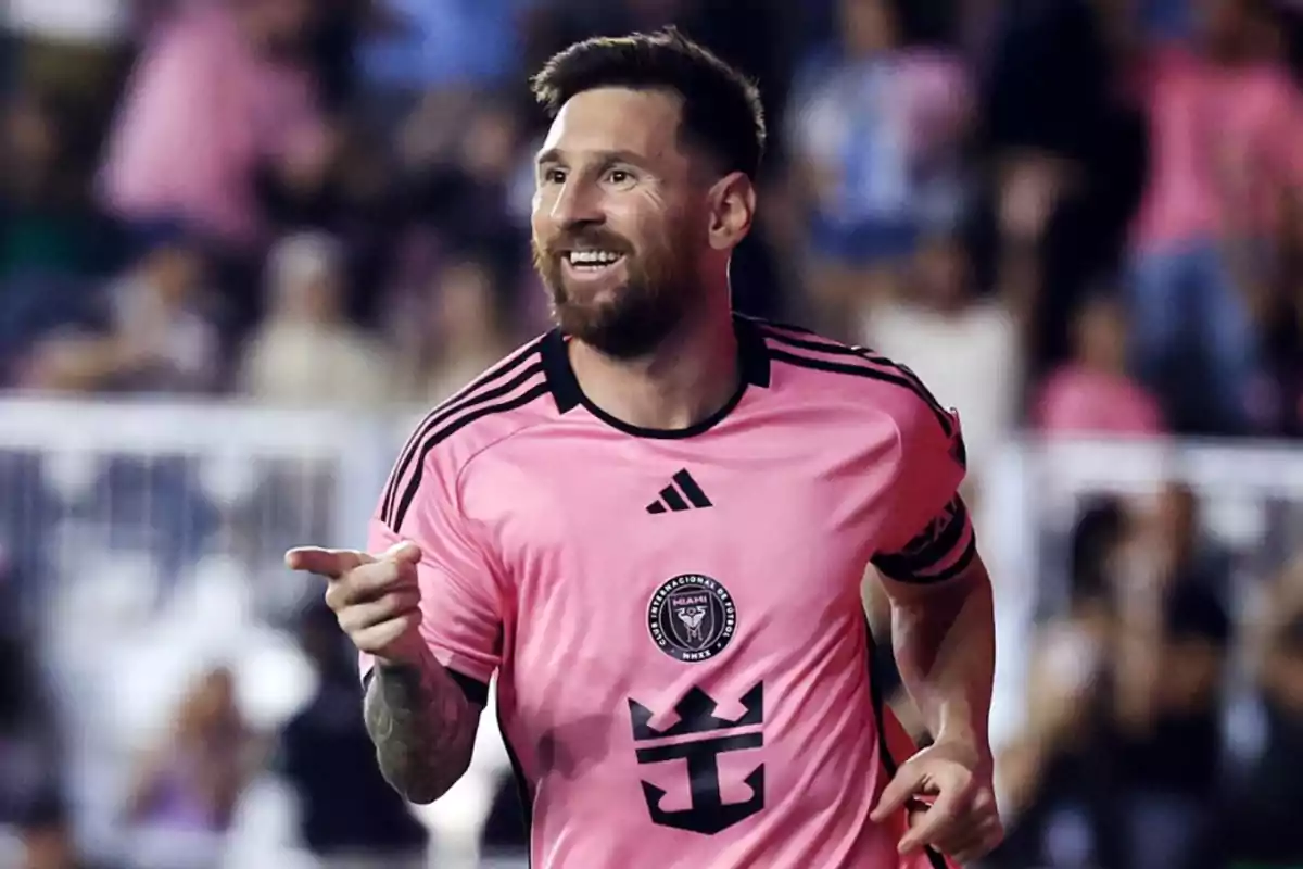Futbolista con camiseta rosa celebrando un gol en un estadio lleno de aficionados