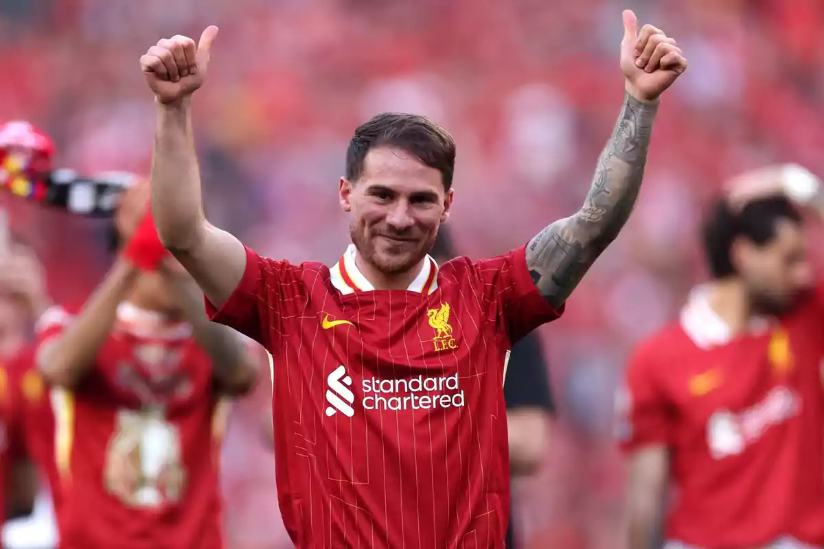 Soccer player in a red uniform celebrating with thumbs up in a stadium. Soccer player in a red uniform celebrating with thumbs up in a stadium.
