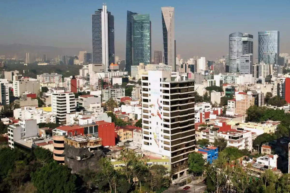 Vista panorámica de una ciudad con edificios altos y modernos rodeados de construcciones más bajas y áreas verdes.