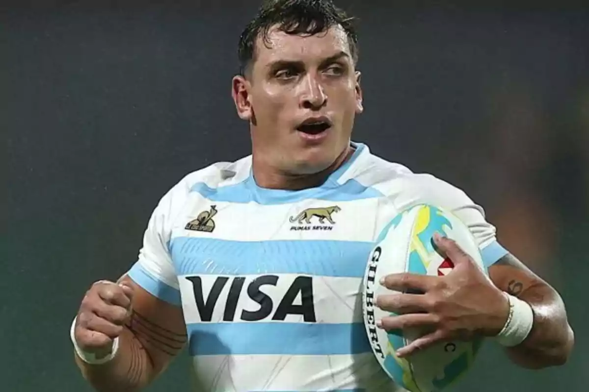 Rugby player in a light blue and white jersey running with the ball in his hands