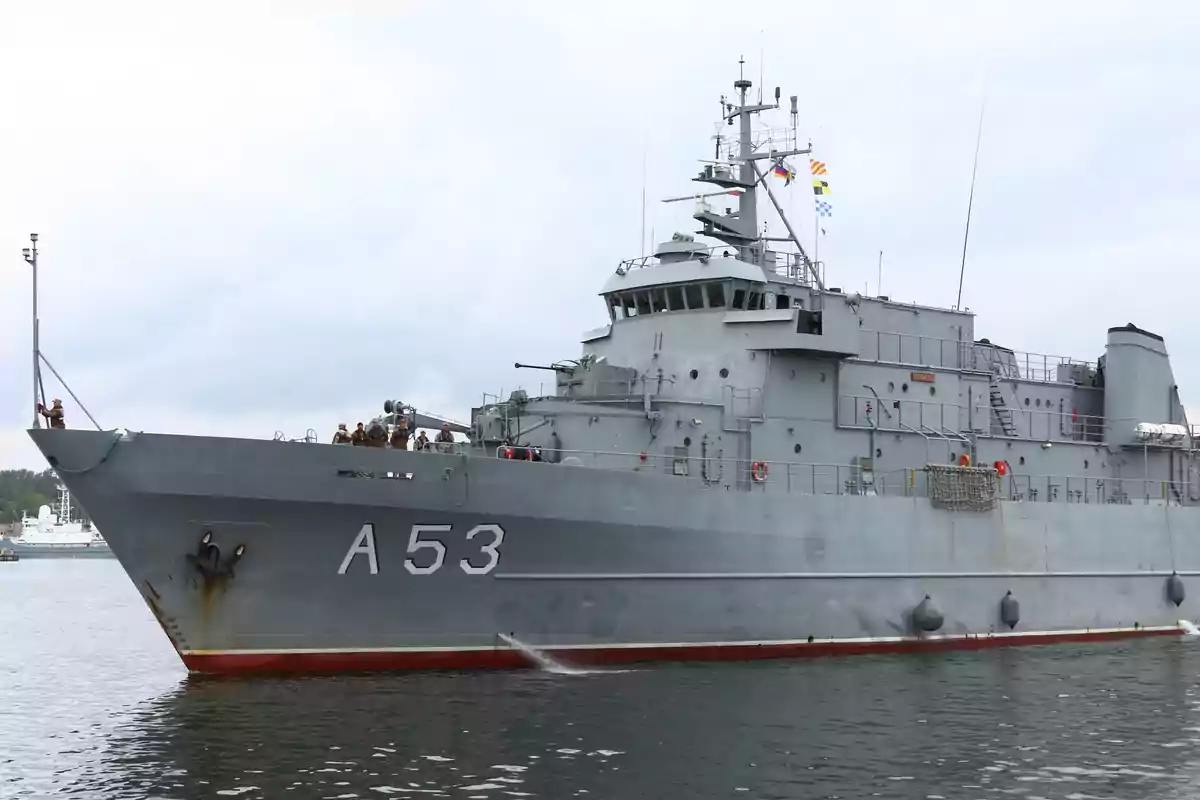 Un buque militar gris con el número A53 en el casco navegando en el agua.