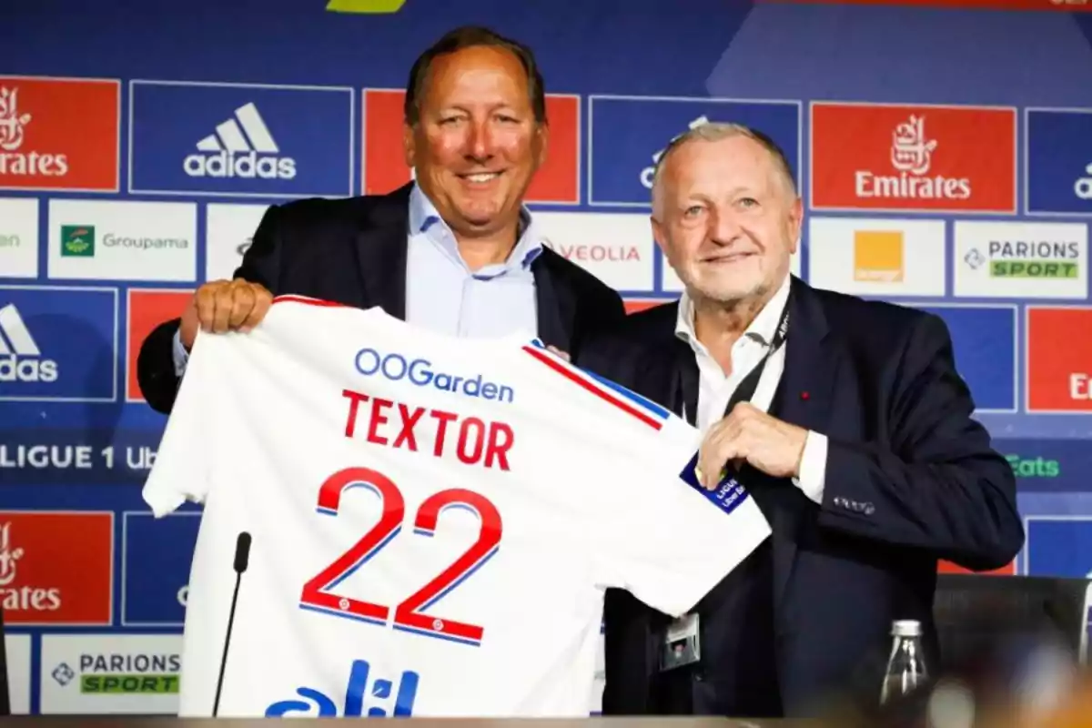 Two men smile while holding a soccer jersey with the name Two men smile while holding a soccer jersey with the name