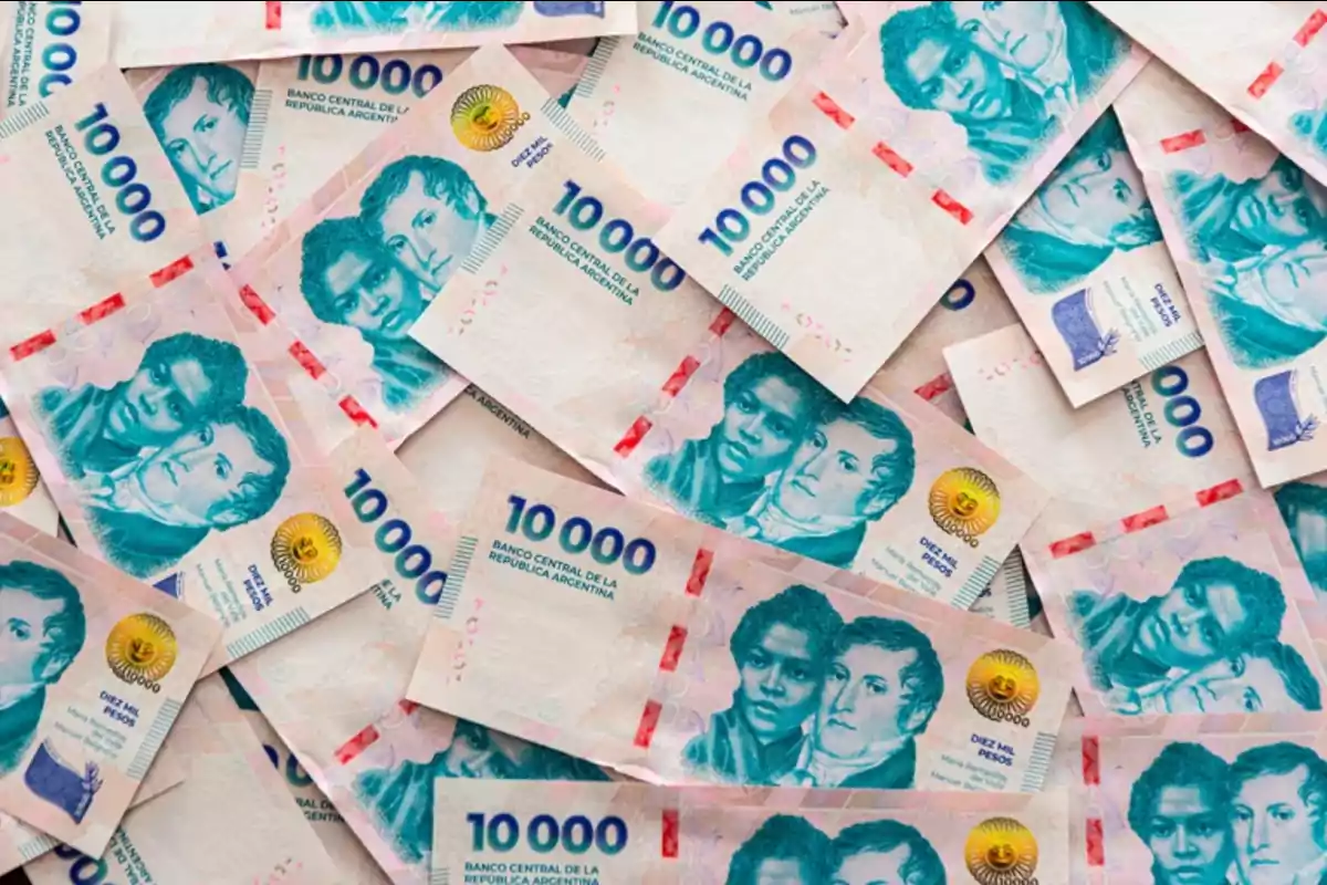 Several new ten-thousand Argentine peso bills scattered on a surface