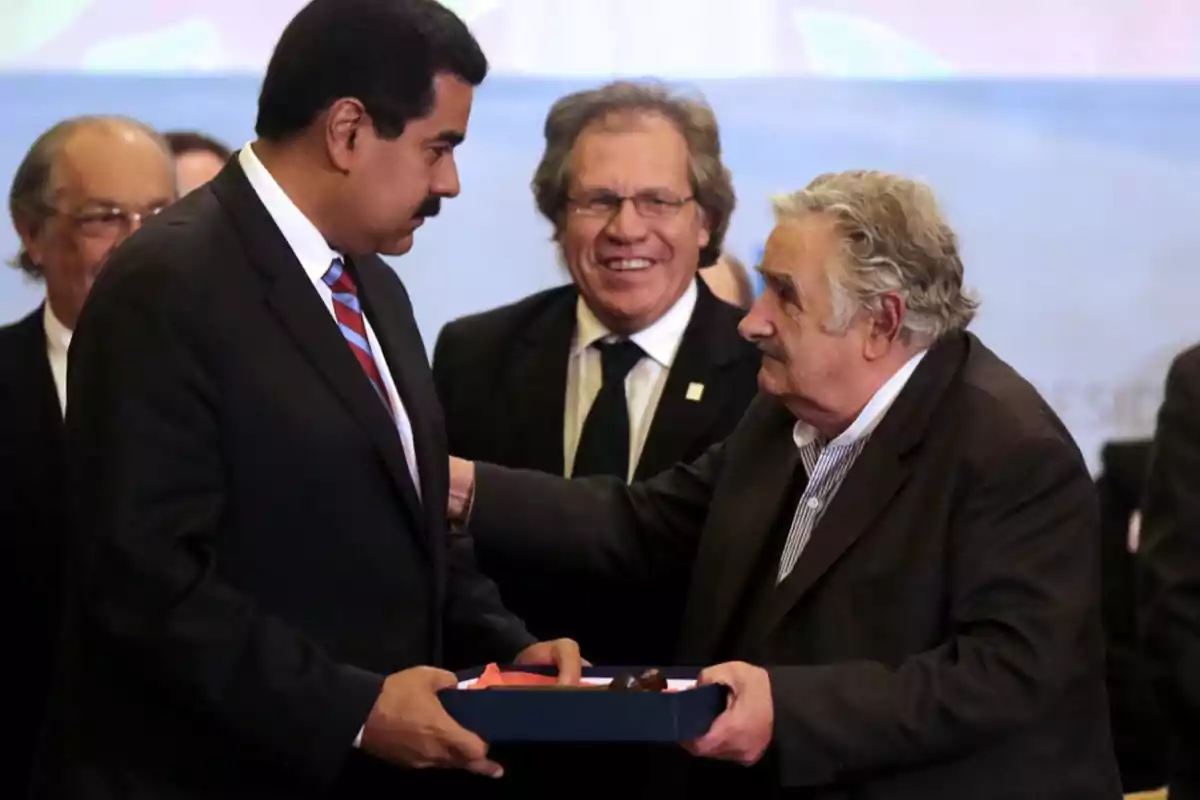 A group of people at a formal event, two of them exchanging an object in a box. A group of people at a formal event, two of them exchanging an object in a box.
