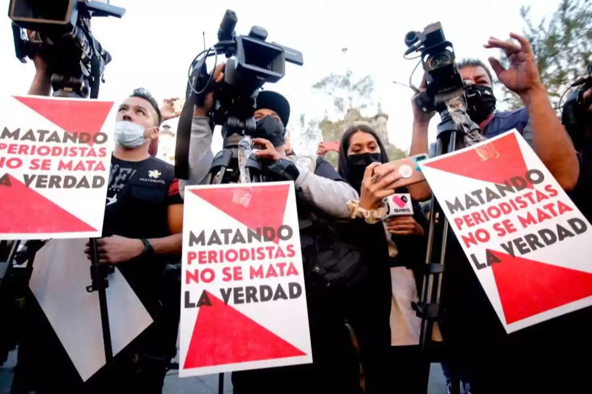 Journalists with cameras and signs that say 