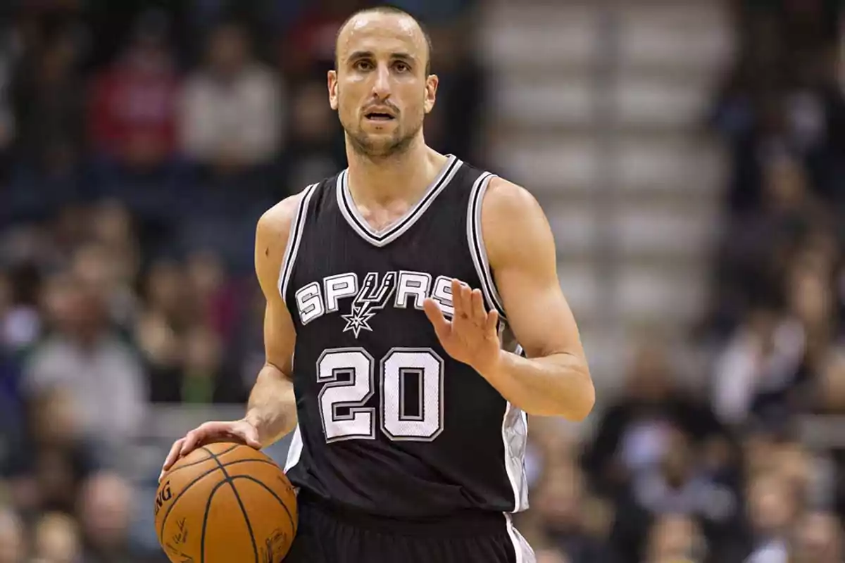 Jugador de baloncesto con el uniforme de los Spurs sosteniendo un balón en la cancha.