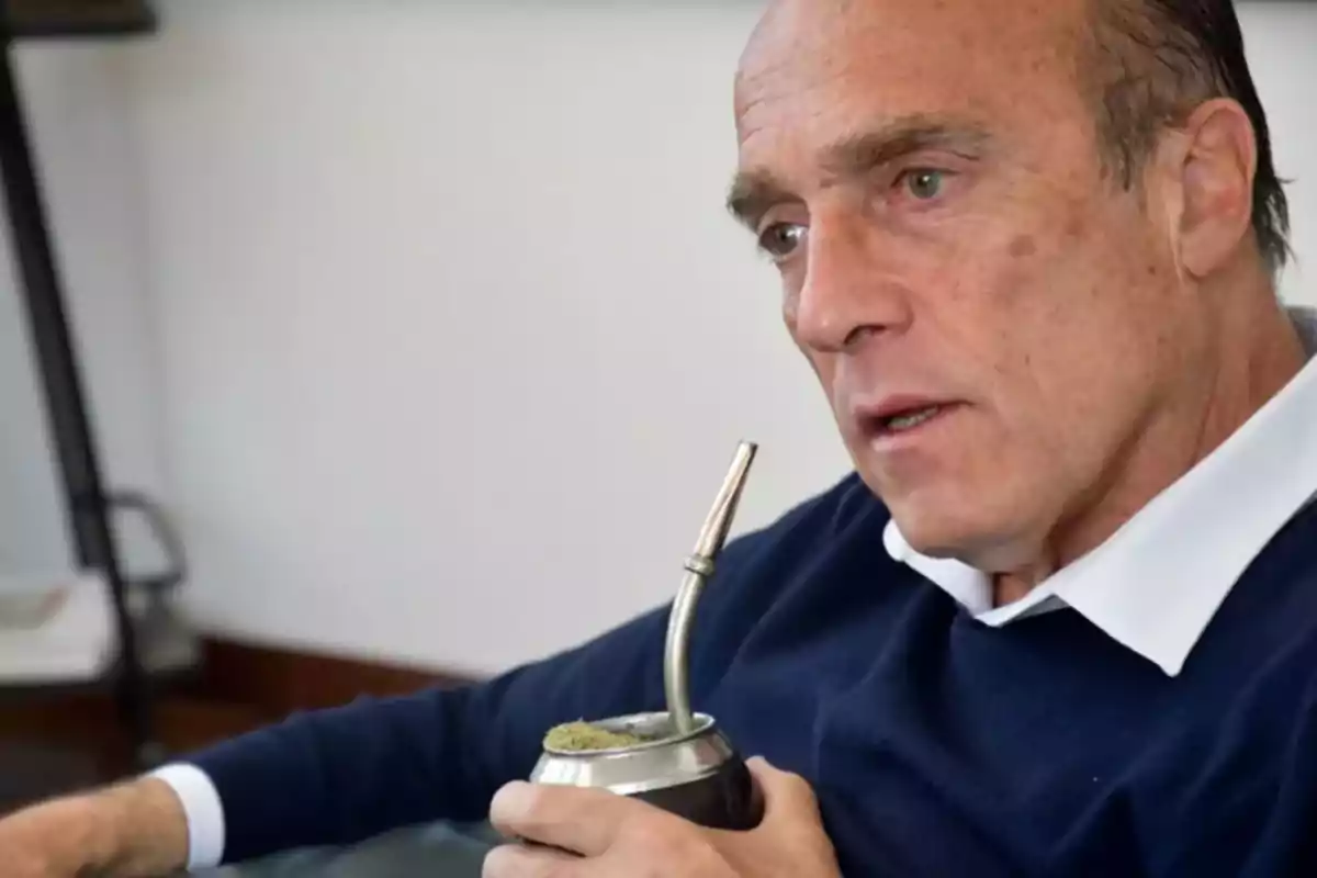 Man holding a mate while sitting and looking forward.