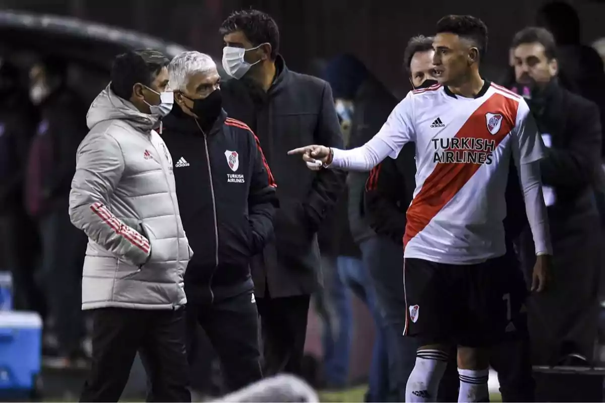 Un jugador de River Plate señala mientras conversa con el cuerpo técnico durante un partido de fútbol Un jugador de River Plate señala mientras conversa con el cuerpo técnico durante un partido de fútbol