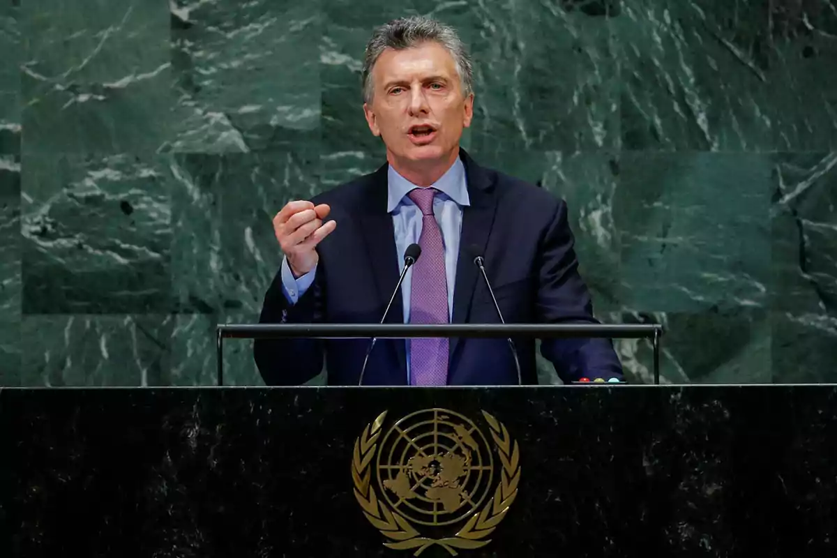 Un hombre hablando en un podio con el emblema de las Naciones Unidas.