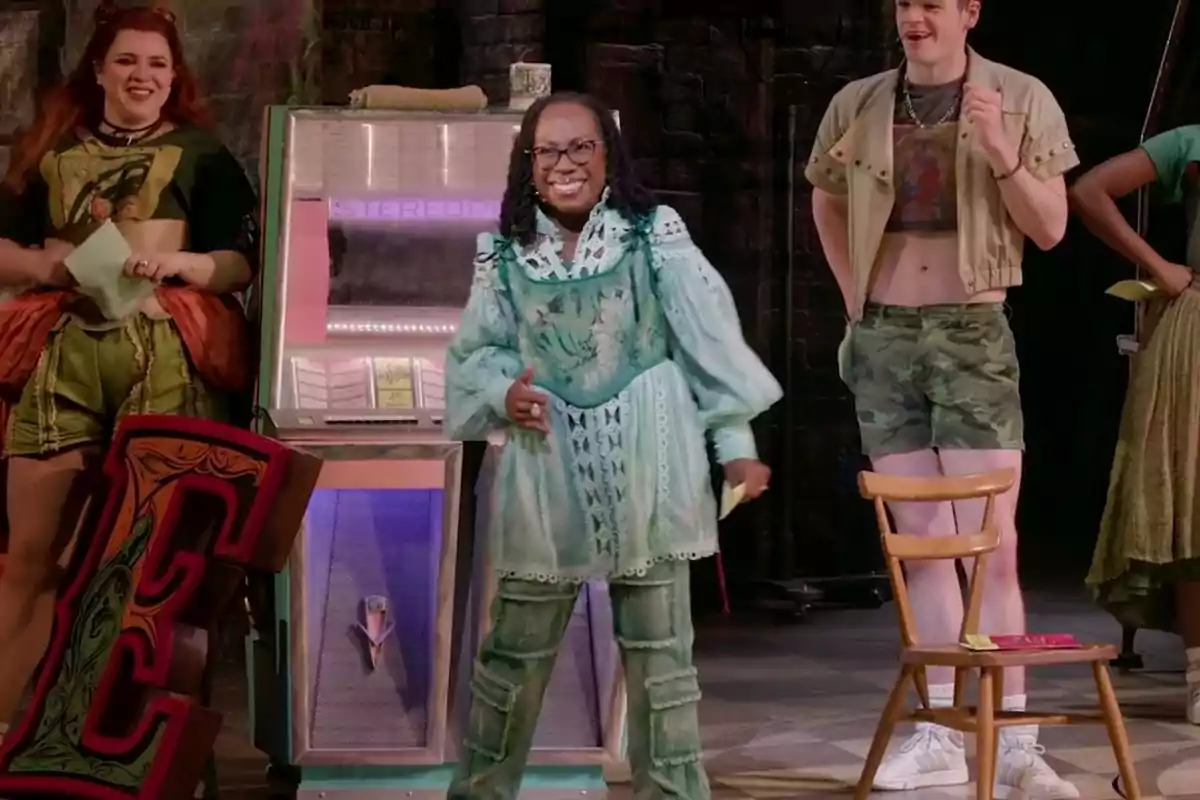 A group of people on a stage with colorful costumes and a jukebox in the background. A group of people on a stage with colorful costumes and a jukebox in the background.