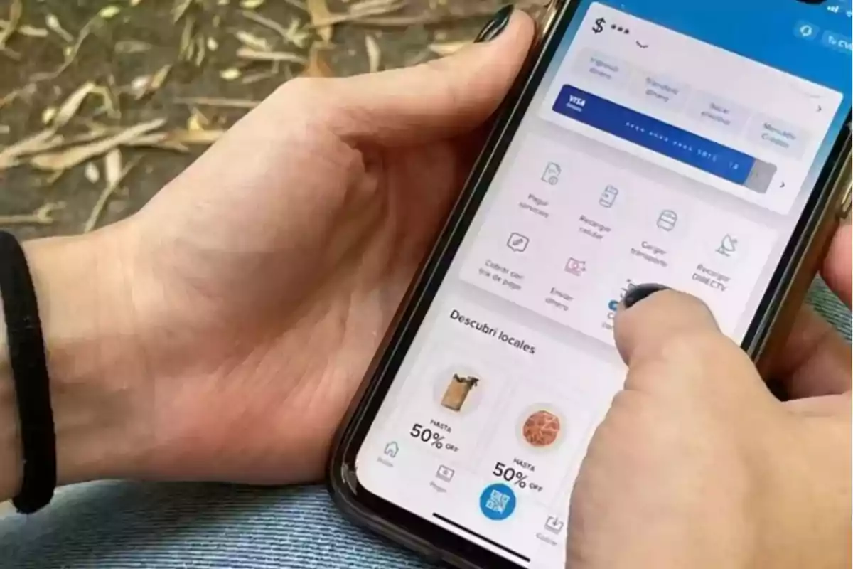 Una persona sostiene un teléfono móvil que muestra una aplicación de banca digital con varias opciones de servicios y descuentos.