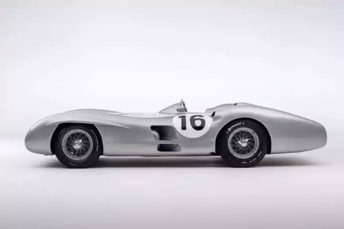 Classic silver race car with the number 16 on the body seen in profile against a white background Classic silver race car with the number 16 on the body seen in profile against a white background