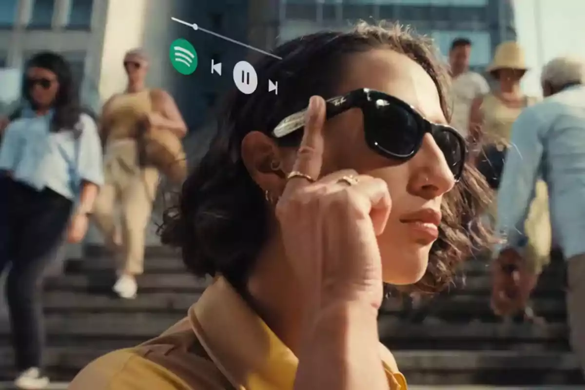 Una persona con gafas de sol toca el lateral de las gafas mientras camina por la calle, con un gráfico de control de música flotando cerca de su cabeza. Una persona con gafas de sol toca el lateral de las gafas mientras camina por la calle, con un gráfico de control de música flotando cerca de su cabeza.