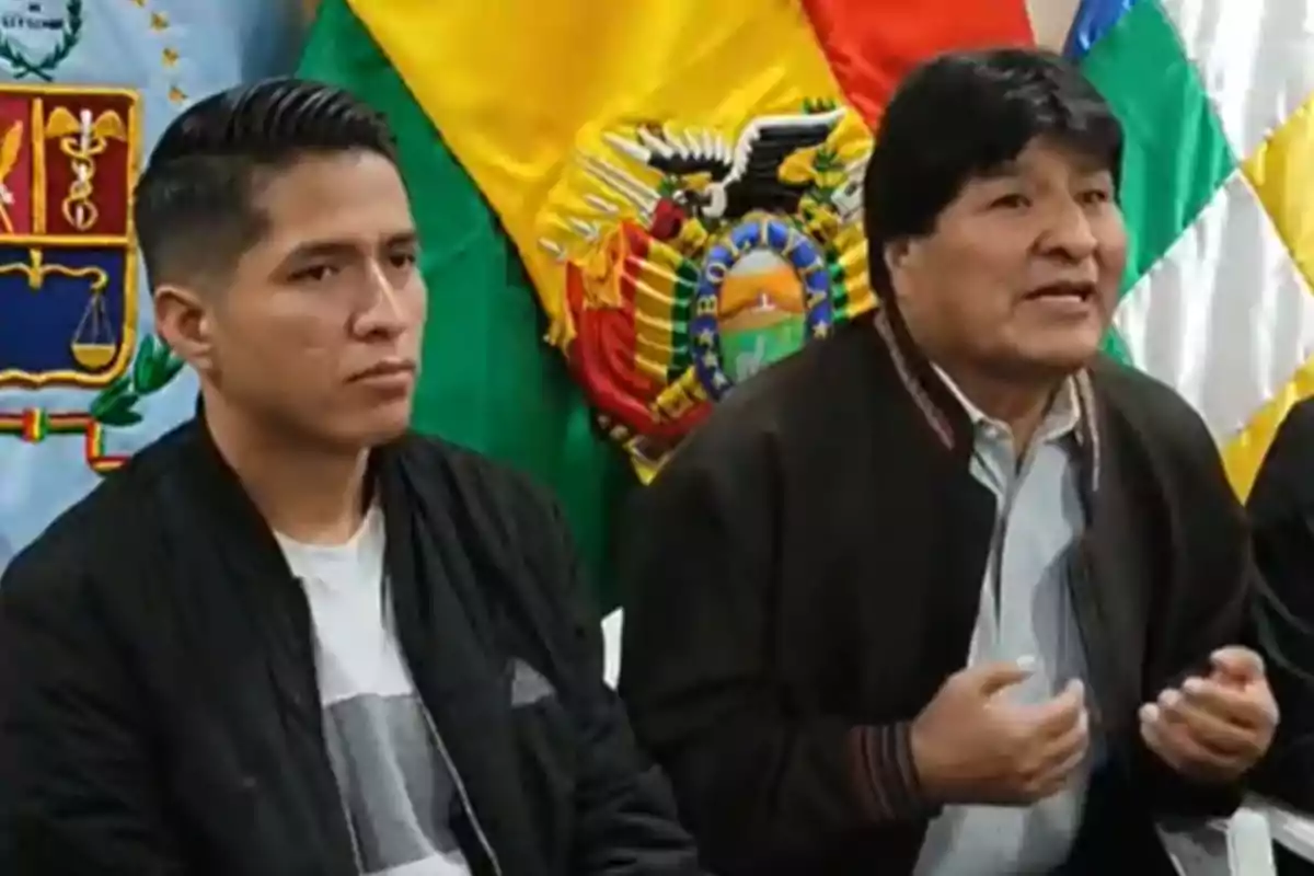 Two men seated in front of Bolivian flags during a press conference Two men seated in front of Bolivian flags during a press conference