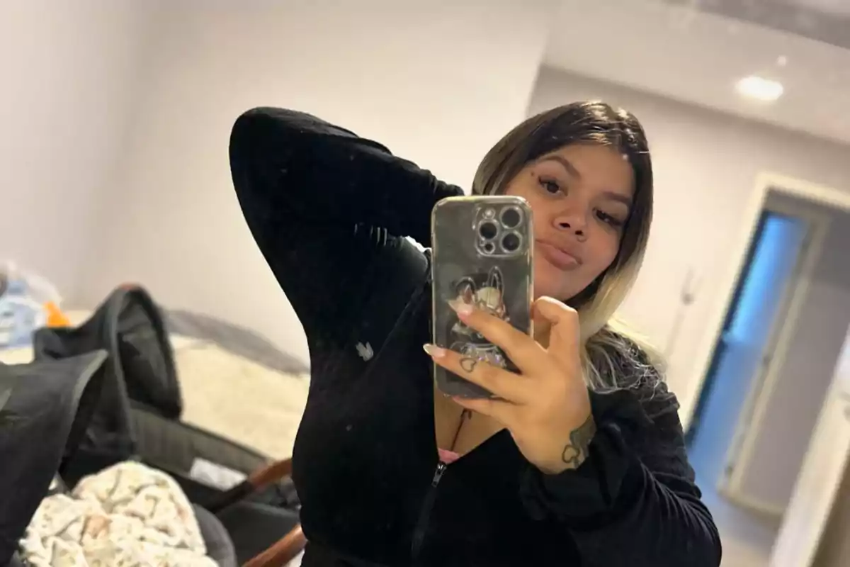 Una persona tomándose una selfie frente a un espejo en una habitación.