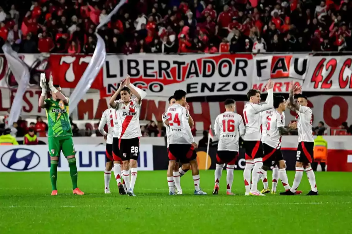 River Plate players applaud and greet the fans in the stadium with flags and crowd in the background. River Plate players applaud and greet the fans in the stadium with flags and crowd in the background.