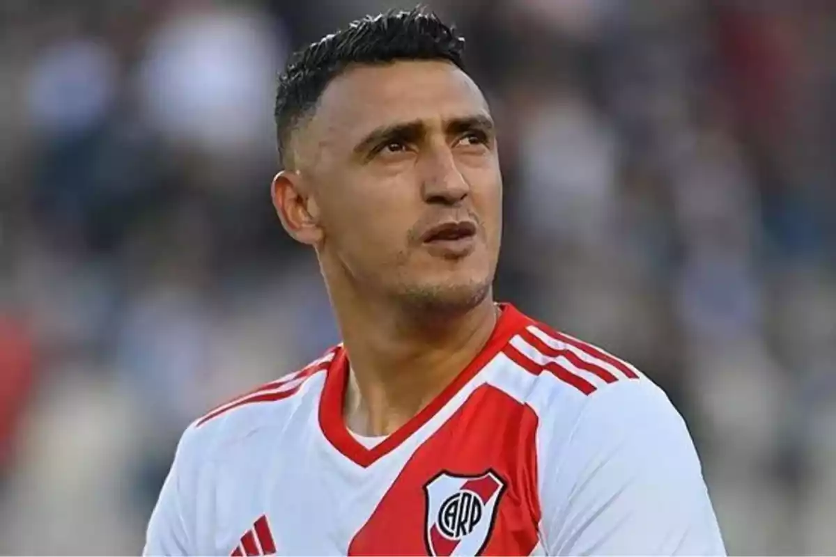 Futbolista con camiseta de River Plate mirando hacia un costado en un estadio
